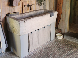 Antique reclaimed stone basin sink salvaged restored and installed in this traditional style Mediterranean home.